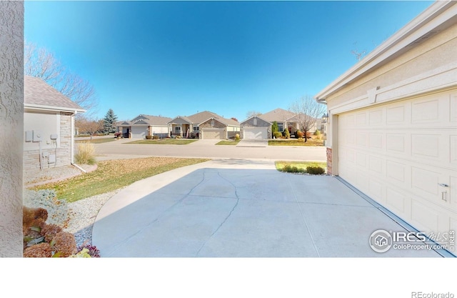 8211 Lighthouse Lane Ct, Windsor, CO 80528 - view of patio featuring a residential view, a garage, and concrete driveway