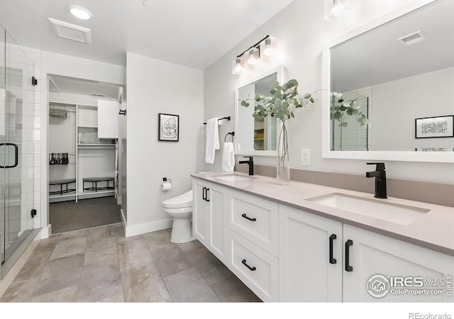 221 E Mountain Ave Unit 319, Fort Collins, CO 80524 - bathroom featuring double vanity, a stall shower, toilet, baseboards, and a spacious closet