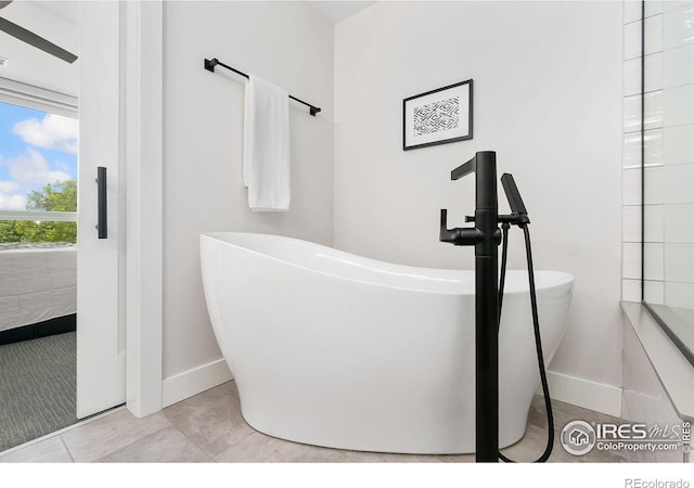 221 E Mountain Ave Unit 319, Fort Collins, CO 80524 - bathroom featuring a freestanding tub, baseboards, and tile patterned floors