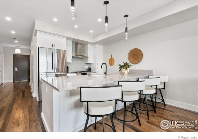 221 E Mountain Ave Unit 319, Fort Collins, CO 80524 - kitchen featuring wall chimney exhaust hood, a sink, tasteful backsplash, white cabinets, and dark wood-style floors