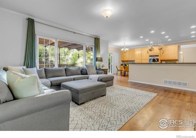 2841 Silver Pl, Superior, CO 80027 - living room with crown molding, light wood-style floors, plenty of natural light, recessed lighting, and a chandelier