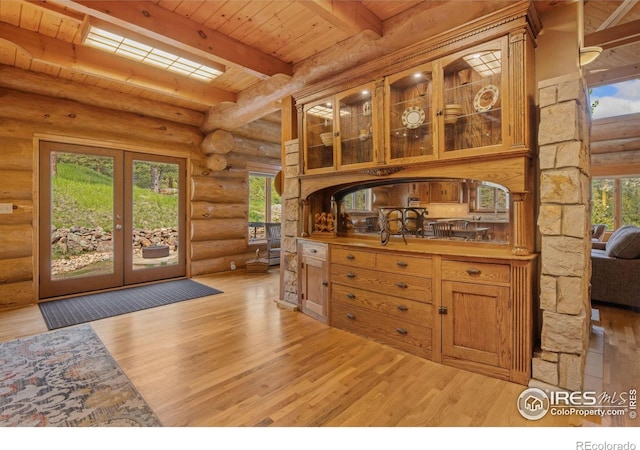 95 Choctaw Rd, Lyons, CO 80540 - kitchen with rustic walls, wooden ceiling with exposed beams, light wood-type flooring, glass insert cabinets, and brown cabinets