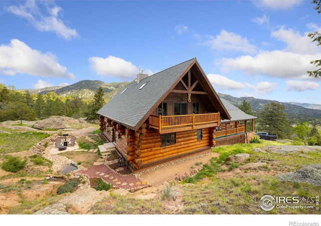 95 Choctaw Rd, Lyons, CO 80540 - view of front of house featuring log siding, a mountain view, a balcony, and a chimney