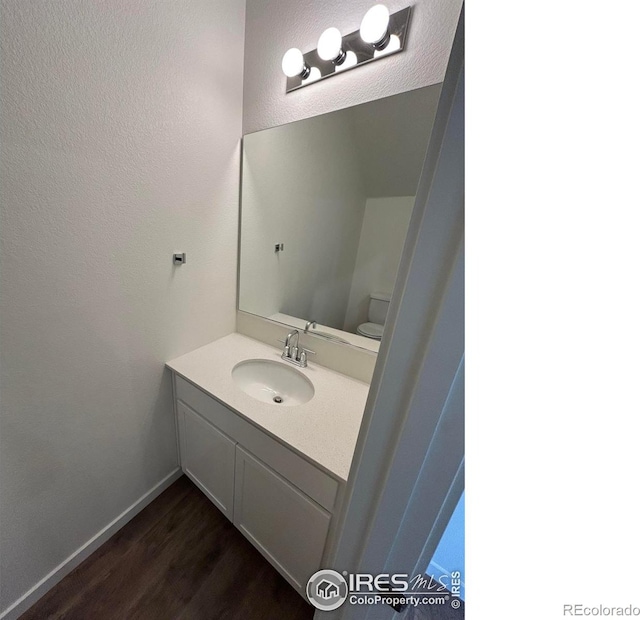 420 Condor Way, Johnstown, CO 80534 - bathroom with wood finished floors, vanity, a textured wall, baseboards, and toilet