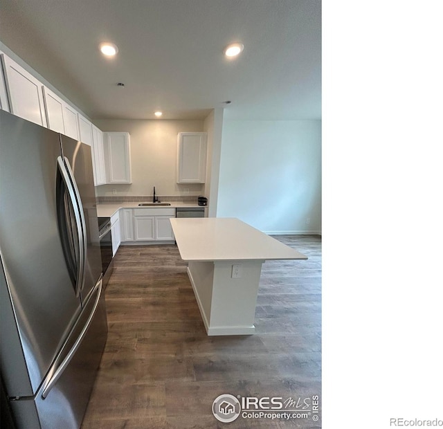 420 Condor Way, Johnstown, CO 80534 - kitchen with appliances with stainless steel finishes, a sink, white cabinets, dark wood-style floors, and a kitchen island