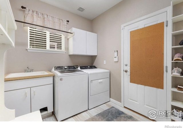 10278 Dover St, Firestone, CO 80504 - laundry area with cabinet space, washing machine and dryer, and light wood-style flooring