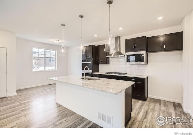 1875 Foggy Brook Dr, Fort Collins, CO 80528 - kitchen featuring wall chimney range hood, appliances with stainless steel finishes, a sink, light wood-type flooring, and backsplash