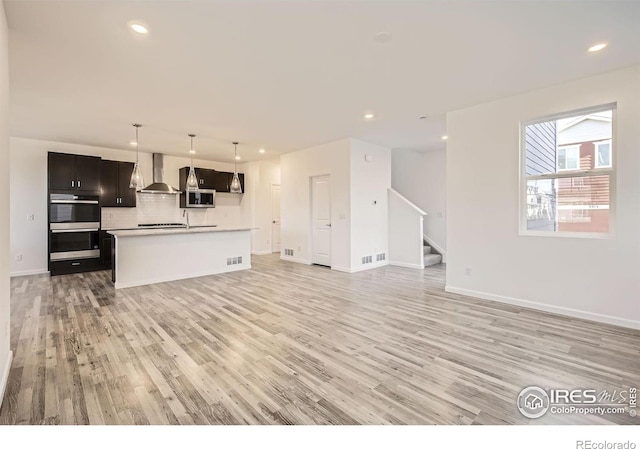 1875 Foggy Brook Dr, Fort Collins, CO 80528 - unfurnished living room with light wood-style flooring, stairs, recessed lighting, a sink, and baseboards