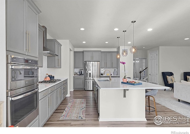 6229 Black Mesa Rd, Frederick, CO 80516 - kitchen featuring gray cabinets, appliances with stainless steel finishes, open floor plan, a sink, and a breakfast bar area