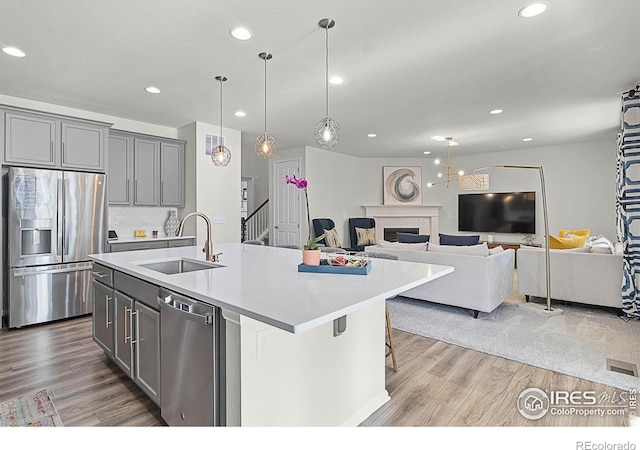 6229 Black Mesa Rd, Frederick, CO 80516 - kitchen featuring appliances with stainless steel finishes, a sink, gray cabinetry, wood finished floors, and recessed lighting