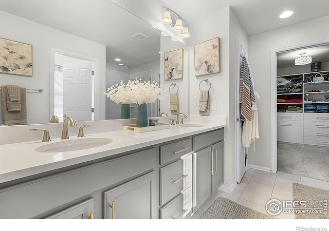 6229 Black Mesa Rd, Frederick, CO 80516 - full bathroom featuring double vanity, a walk in closet, a tile shower, tile patterned flooring, and recessed lighting
