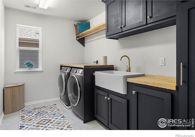 6229 Black Mesa Rd, Frederick, CO 80516 - laundry area featuring independent washer and dryer, cabinet space, baseboards, and light tile patterned floors