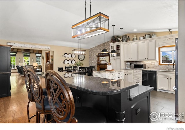 1738 S Estrella Ave, Loveland, CO 80537 - kitchen with appliances with stainless steel finishes, a center island, vaulted ceiling, a sink, and a breakfast bar
