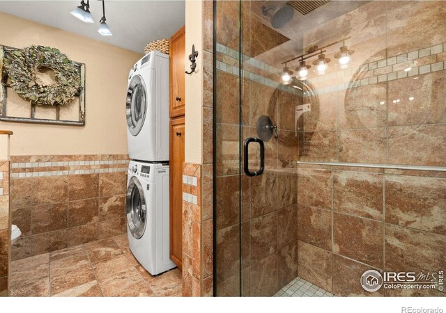 1738 S Estrella Ave, Loveland, CO 80537 - full bath featuring stacked washer and clothes dryer, tile walls, a stall shower, and a wainscoted wall