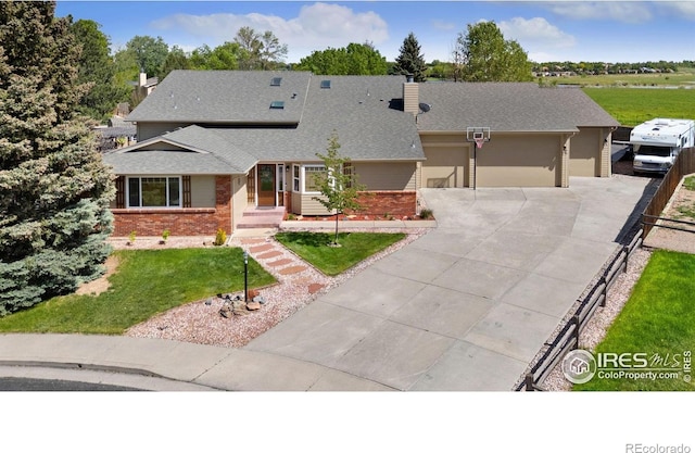 1738 S Estrella Ave, Loveland, CO 80537 - view of front facade with brick siding, a chimney, concrete driveway, roof with shingles, and a garage