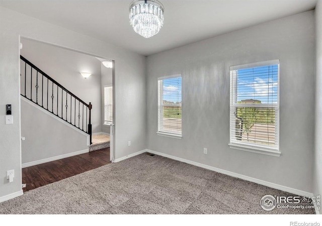 993 Ouzel Falls Rd, Severance, CO 80550 - spare room with carpet flooring, baseboards, a chandelier, and stairs