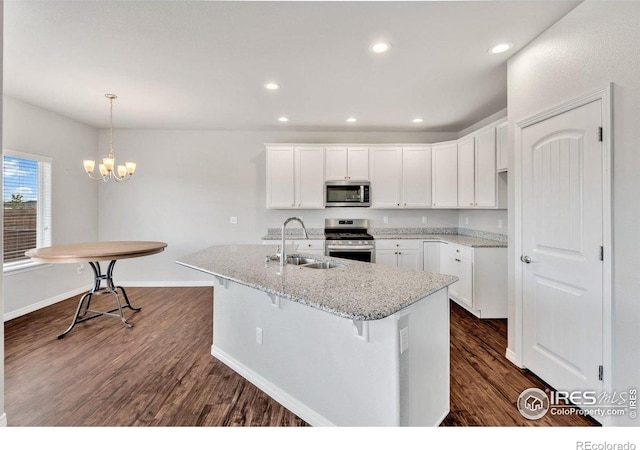 993 Ouzel Falls Rd, Severance, CO 80550 - kitchen with stainless steel appliances, a sink, dark wood-style flooring, white cabinets, and recessed lighting