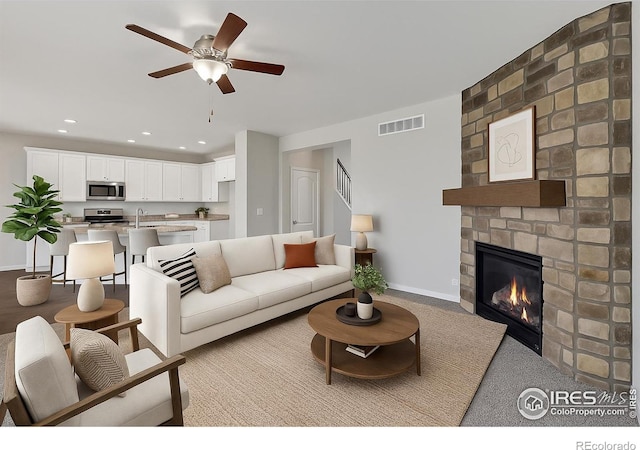 993 Ouzel Falls Rd, Severance, CO 80550 - living room with ceiling fan, a large fireplace, baseboards, recessed lighting, and light carpet