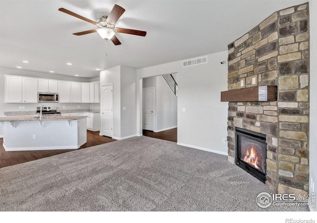 993 Ouzel Falls Rd, Severance, CO 80550 - kitchen with stainless steel appliances, open floor plan, white cabinets, a ceiling fan, and a breakfast bar area