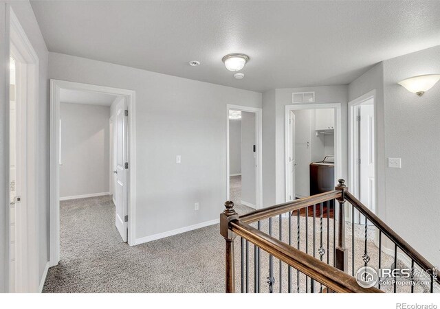993 Ouzel Falls Rd, Severance, CO 80550 - hallway with an upstairs landing, washer / dryer, carpet floors, and baseboards