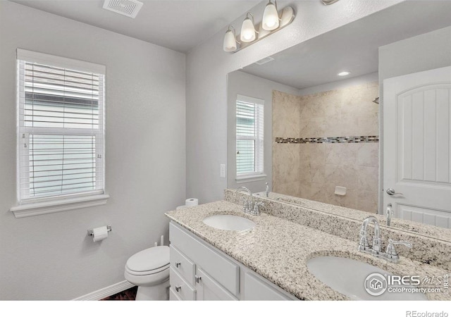 993 Ouzel Falls Rd, Severance, CO 80550 - bathroom with double vanity, baseboards, toilet, a tile shower, and wood finished floors