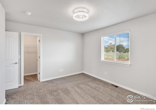993 Ouzel Falls Rd, Severance, CO 80550 - unfurnished bedroom with carpet flooring, a walk in closet, and baseboards