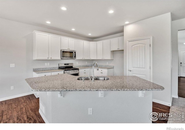 993 Ouzel Falls Rd, Severance, CO 80550 - kitchen with stainless steel appliances, white cabinets, dark wood-type flooring, and recessed lighting