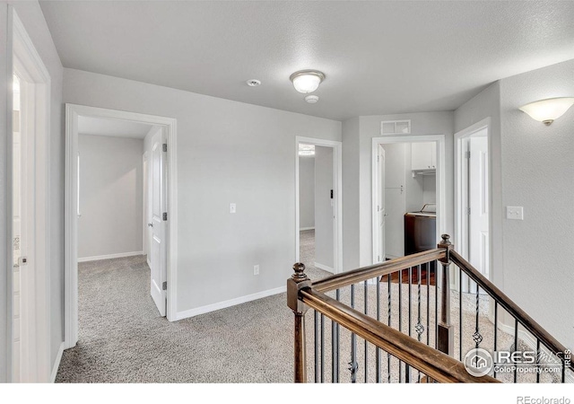 993 Ouzel Falls Rd, Severance, CO 80550 - hall featuring an upstairs landing, carpet floors, and washer / dryer