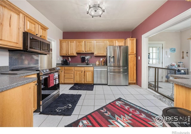 23462 County Road 55, Kersey, CO 80644 - kitchen featuring appliances with stainless steel finishes, a sink, light tile patterned floors, and dark countertops