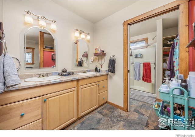 23462 County Road 55, Kersey, CO 80644 - full bath with double vanity, stone finish floors, a stall shower, baseboards, and a walk in closet