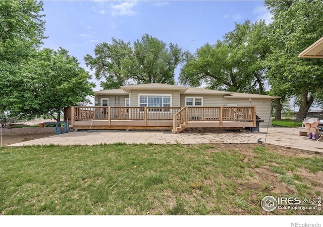 23462 County Road 55, Kersey, CO 80644 - back of property featuring a wooden deck, a patio area, and a yard