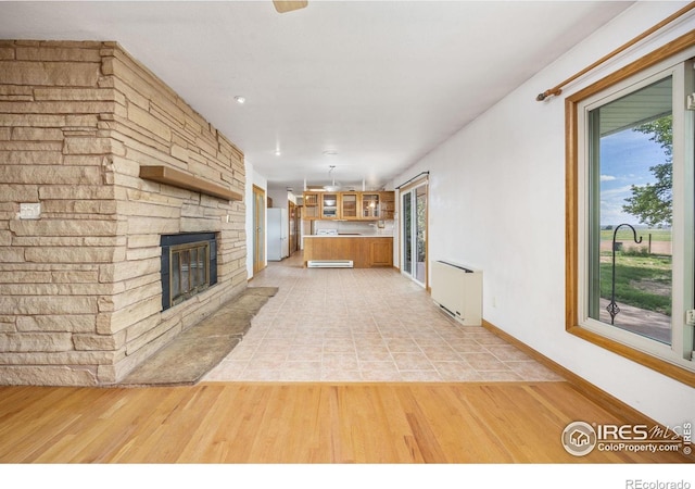 23462 County Road 55, Kersey, CO 80644 - unfurnished living room featuring a fireplace, light wood-style flooring, and baseboards