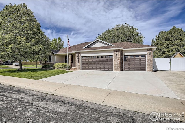 520 N Harding Ave, Johnstown, CO 80534 - ranch-style home featuring an attached garage, driveway, brick siding, and a gate