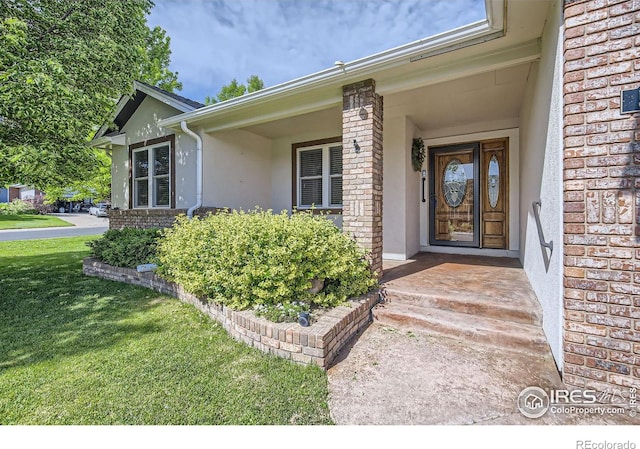 520 N Harding Ave, Johnstown, CO 80534 - entrance to property featuring stucco siding, brick siding, and a lawn