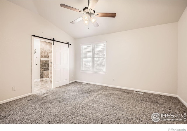 520 N Harding Ave, Johnstown, CO 80534 - unfurnished bedroom with carpet flooring, baseboards, vaulted ceiling, a barn door, and connected bathroom