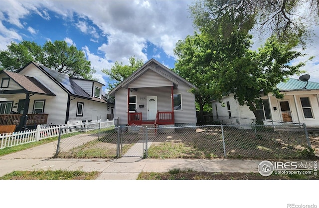 305 Phelps St, Sterling, CO 80751 - shotgun-style home with covered porch, a fenced front yard, and a gate