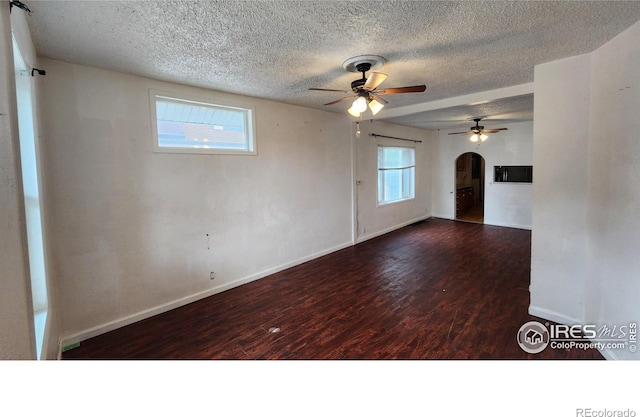 305 Phelps St, Sterling, CO 80751 - empty room featuring arched walkways, a ceiling fan, a textured ceiling, wood finished floors, and baseboards