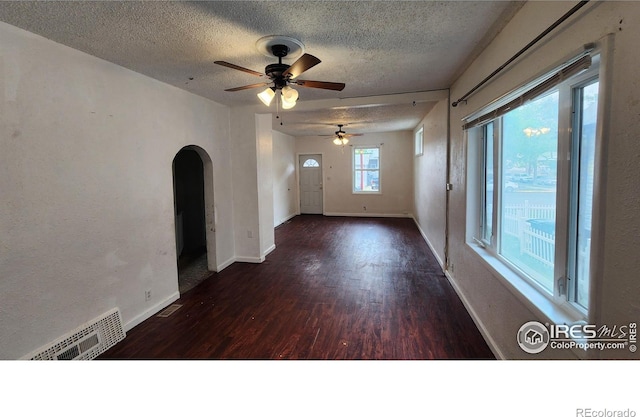 305 Phelps St, Sterling, CO 80751 - unfurnished room featuring arched walkways, a textured ceiling, wood finished floors, ceiling fan, and baseboards