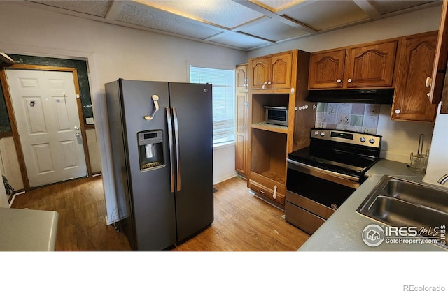 305 Phelps St, Sterling, CO 80751 - kitchen featuring fridge with ice dispenser, stainless steel range with electric cooktop, under cabinet range hood, and wood finished floors