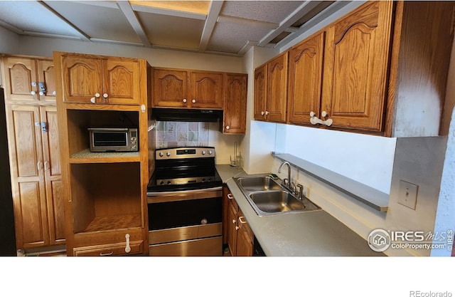 305 Phelps St, Sterling, CO 80751 - kitchen with stainless steel range with electric cooktop, under cabinet range hood, a sink, and brown cabinets