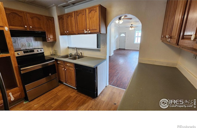 305 Phelps St, Sterling, CO 80751 - kitchen with stainless steel electric range, dishwasher, arched walkways, under cabinet range hood, and a sink