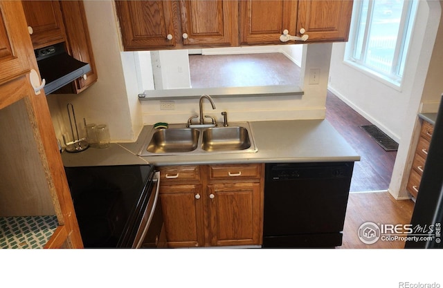 305 Phelps St, Sterling, CO 80751 - kitchen featuring black dishwasher, electric range, a sink, exhaust hood, and brown cabinets
