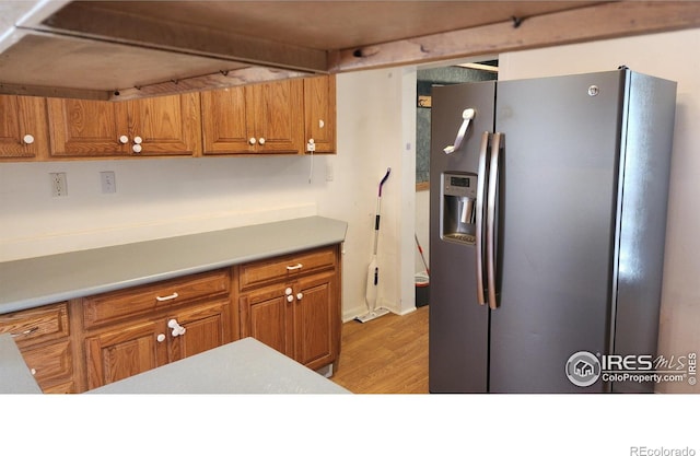 305 Phelps St, Sterling, CO 80751 - kitchen featuring stainless steel refrigerator with ice dispenser, brown cabinetry, and light wood-type flooring