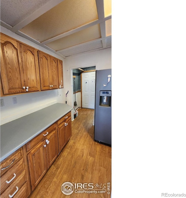 305 Phelps St, Sterling, CO 80751 - kitchen with refrigerator with ice dispenser, light wood finished floors, and brown cabinets