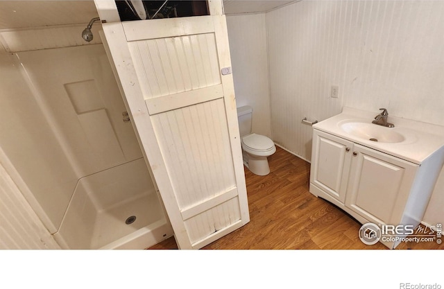 305 Phelps St, Sterling, CO 80751 - bathroom with a stall shower, toilet, wood finished floors, and vanity