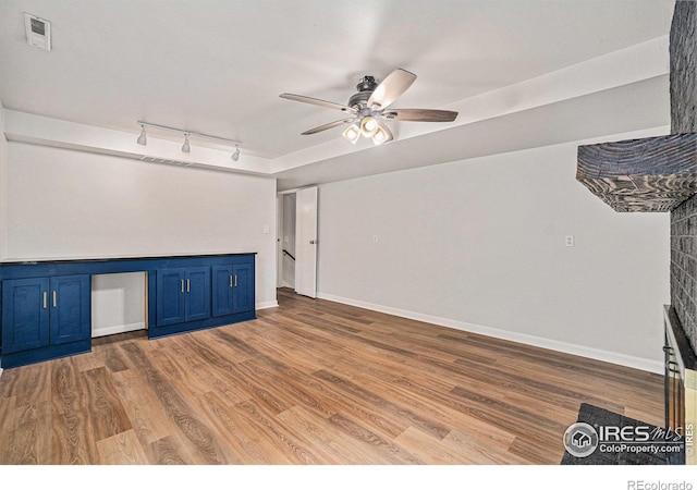 2824 Edinburgh Ct, Fort Collins, CO 80525 - unfurnished living room featuring ceiling fan, wood finished floors, a desk, track lighting, and baseboards