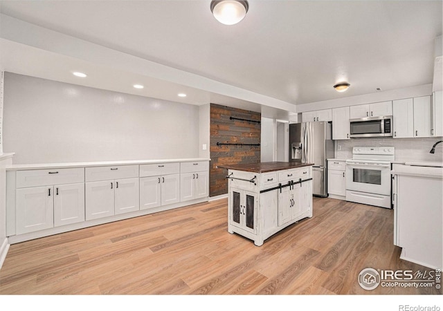2824 Edinburgh Ct, Fort Collins, CO 80525 - kitchen featuring stainless steel appliances, white cabinetry, light wood-type flooring, a kitchen island, and a sink