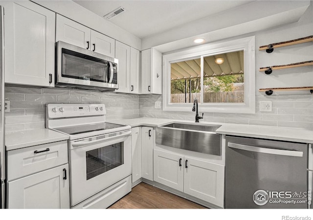 2824 Edinburgh Ct, Fort Collins, CO 80525 - kitchen featuring stainless steel appliances, a sink, light countertops, white cabinetry, and tasteful backsplash
