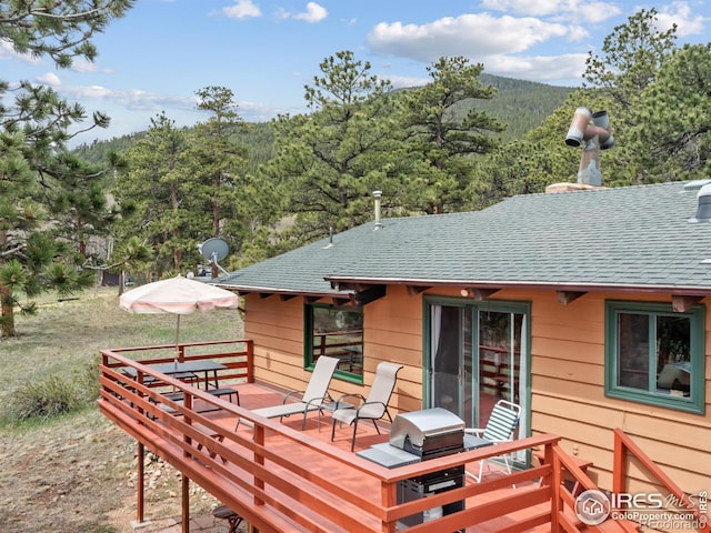 839 Ski Rd, Allenspark, CO 80510 - back of house featuring roof with shingles, a wooden deck, and a view of trees