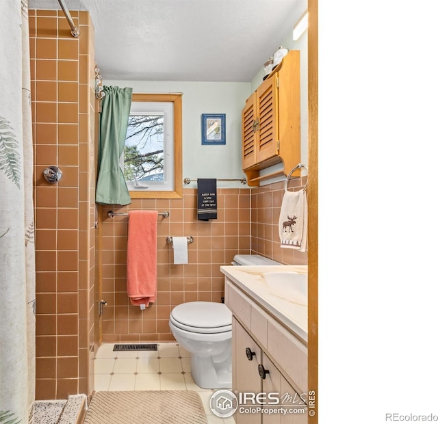 839 Ski Rd, Allenspark, CO 80510 - full bath featuring tile walls, a shower stall, toilet, vanity, and tile patterned flooring
